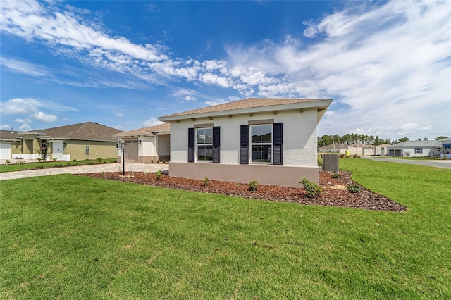 10553 SW 98th Pl, Ocala, FL 34481 - view of front of property featuring a front lawn, an attached garage, stucco siding, driveway, and central AC unit