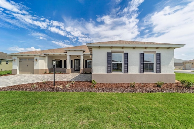 10553 SW 98th Pl, Ocala, FL 34481 - mediterranean / spanish home featuring stucco siding, decorative driveway, a front yard, and an attached garage