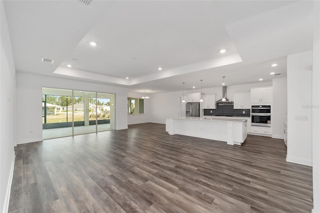 10553 SW 98th Pl, Ocala, FL 34481 - unfurnished living room featuring a raised ceiling, recessed lighting, baseboards, and dark wood-type flooring