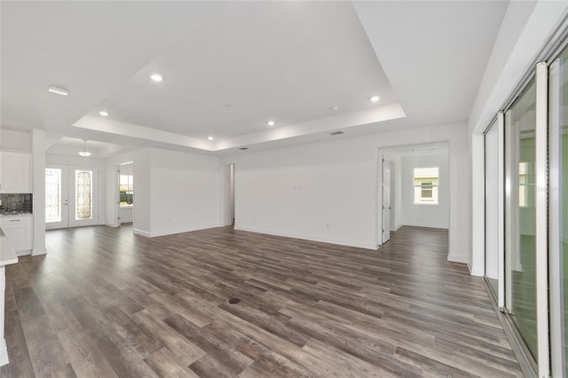 10553 SW 98th Pl, Ocala, FL 34481 - unfurnished living room with a tray ceiling, recessed lighting, dark wood-style flooring, and plenty of natural light