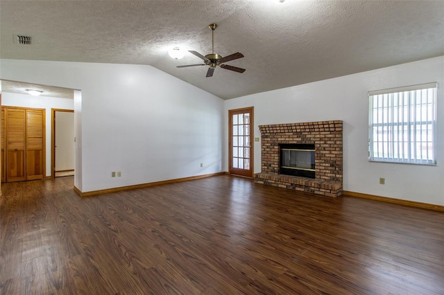 3295 SE 56th Ave, Ocala, FL 34480 - unfurnished living room featuring a ceiling fan, dark wood finished floors, lofted ceiling, a fireplace, and a textured ceiling