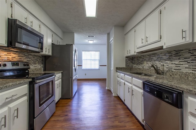 3295 SE 56th Ave, Ocala, FL 34480 - kitchen featuring appliances with stainless steel finishes, a sink, a textured ceiling, dark wood finished floors, and white cabinets