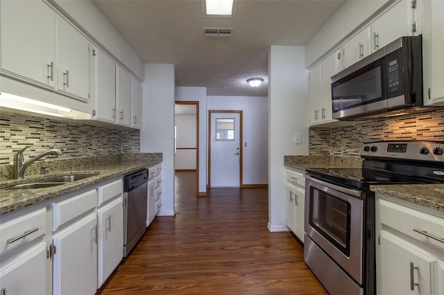 3295 SE 56th Ave, Ocala, FL 34480 - kitchen with stainless steel appliances, a sink, dark wood finished floors, white cabinets, and decorative backsplash