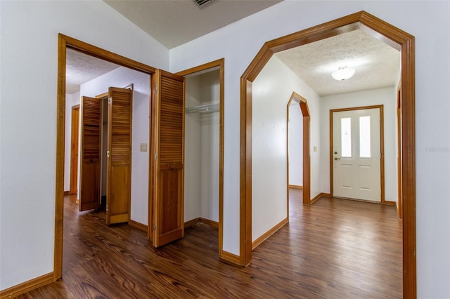 3295 SE 56th Ave, Ocala, FL 34480 - entrance foyer with dark wood-style floors, baseboards, arched walkways, and a textured ceiling