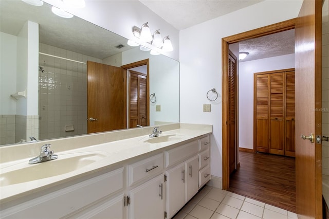 3295 SE 56th Ave, Ocala, FL 34480 - full bathroom featuring tile patterned flooring, double vanity, a textured ceiling, a closet, and baseboards