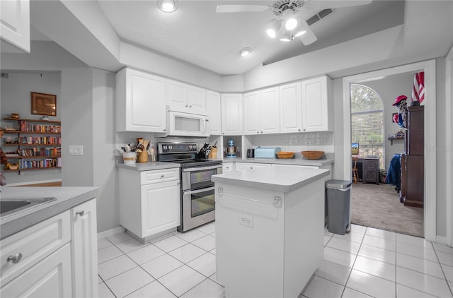 8015 N Tower Way, Citrus Springs, FL 34434 - kitchen featuring white microwave, double oven range, light countertops, a ceiling fan, and light tile patterned floors