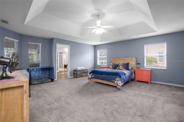 8015 N Tower Way, Citrus Springs, FL 34434 - carpeted bedroom featuring a tray ceiling, multiple windows, baseboards, and ceiling fan