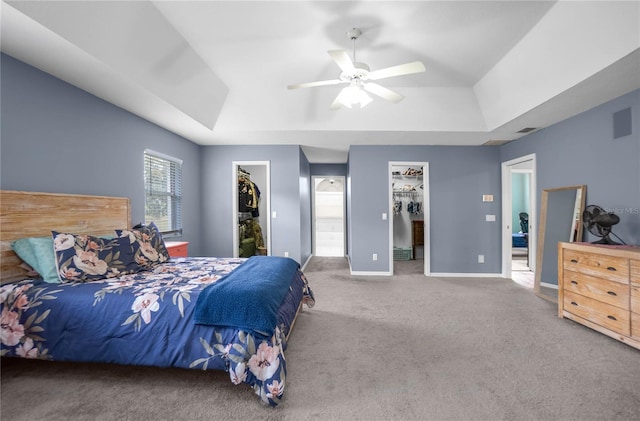 8015 N Tower Way, Citrus Springs, FL 34434 - carpeted bedroom with a walk in closet, a tray ceiling, a closet, baseboards, and a ceiling fan
