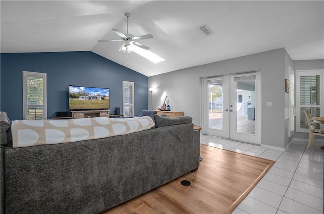 8015 N Tower Way, Citrus Springs, FL 34434 - tiled living area with a ceiling fan, french doors, vaulted ceiling, baseboards, and a skylight
