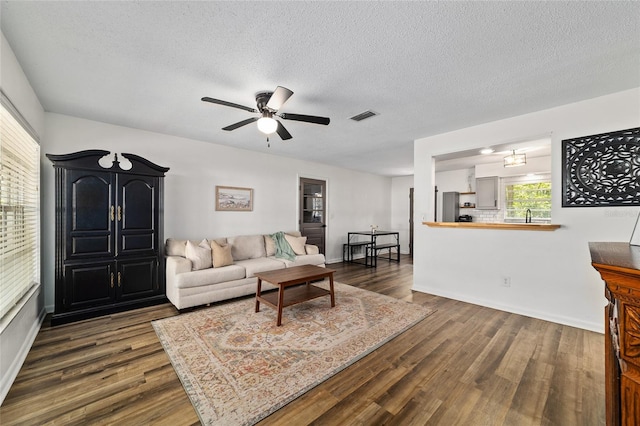 4601 SE 18th Ave, Ocala, FL 34480 - living room featuring dark wood-style floors, ceiling fan, a textured ceiling, and baseboards