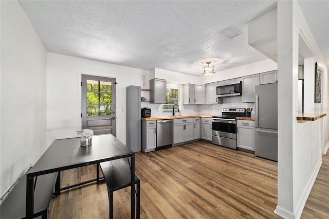 4601 SE 18th Ave, Ocala, FL 34480 - kitchen featuring appliances with stainless steel finishes, gray cabinets, dark wood finished floors, wood counters, and a textured ceiling