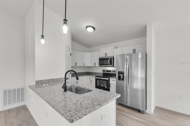 5701 NW 6th Pl, Ocala, FL 34482 - kitchen with stainless steel appliances, a sink, a peninsula, white cabinets, and light wood finished floors