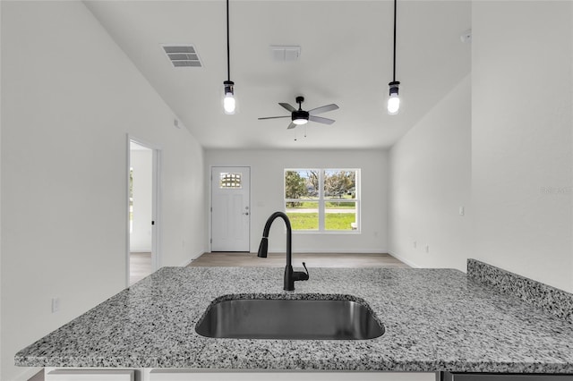 5701 NW 6th Pl, Ocala, FL 34482 - kitchen with a sink, open floor plan, light stone countertops, ceiling fan, and light wood-style flooring