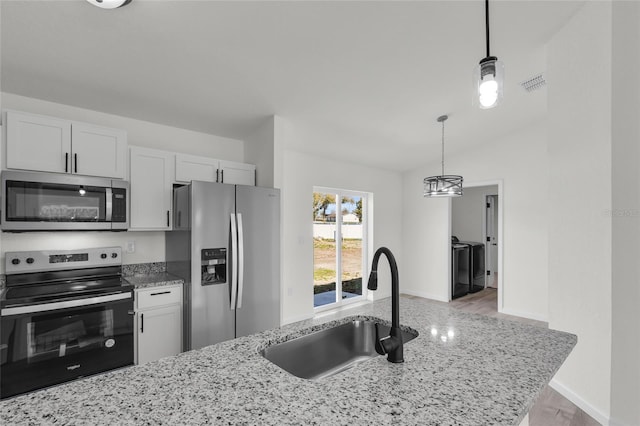 5701 NW 6th Pl, Ocala, FL 34482 - kitchen featuring stainless steel appliances, a sink, washing machine and dryer, decorative light fixtures, and light stone countertops