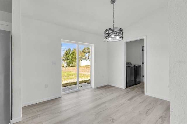 5701 NW 6th Pl, Ocala, FL 34482 - unfurnished dining area with washing machine and dryer, light wood-style floors, a chandelier, and baseboards