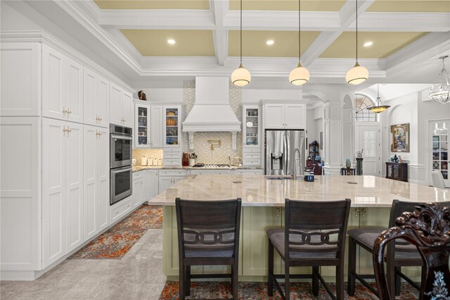 6573 S Magnolia Ave, Ocala, FL 34471 - kitchen with custom exhaust hood, appliances with stainless steel finishes, coffered ceiling, crown molding, and decorative backsplash