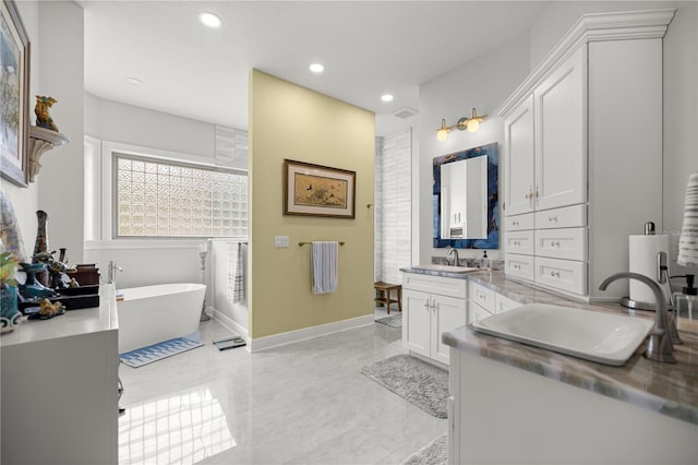 6573 S Magnolia Ave, Ocala, FL 34471 - bathroom with two vanities, a freestanding tub, recessed lighting, and baseboards
