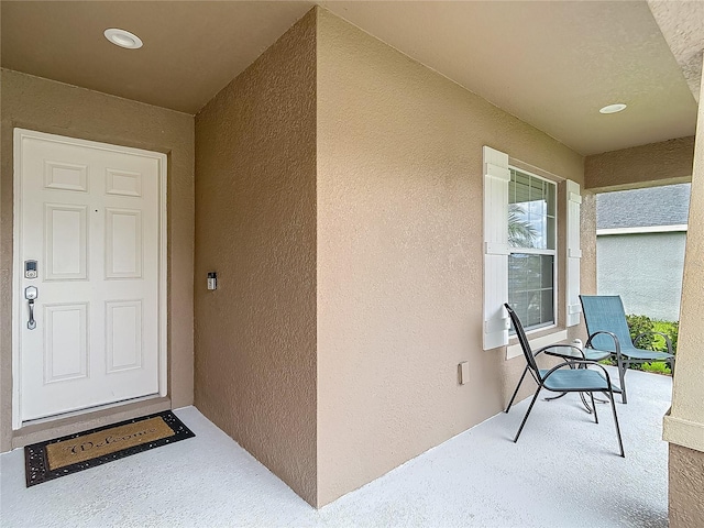 6812 Gideon Cir, Zephyrhills, FL 33541 - doorway to property with stucco siding and covered porch