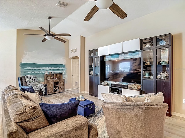 6812 Gideon Cir, Zephyrhills, FL 33541 - living room with a ceiling fan, lofted ceiling, light wood-style floors, arched walkways, and baseboards