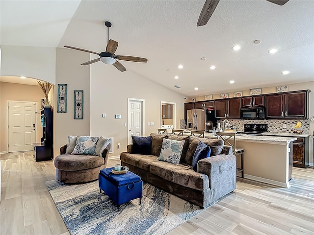 6812 Gideon Cir, Zephyrhills, FL 33541 - living room with a ceiling fan, lofted ceiling, light wood-style floors, recessed lighting, and a textured ceiling