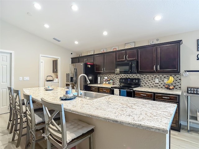 6812 Gideon Cir, Zephyrhills, FL 33541 - kitchen with black appliances, a sink, tasteful backsplash, a kitchen breakfast bar, and lofted ceiling