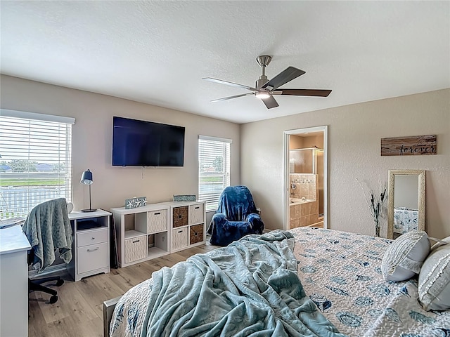 6812 Gideon Cir, Zephyrhills, FL 33541 - bedroom featuring multiple windows, light wood-type flooring, ensuite bathroom, a ceiling fan, and a textured ceiling