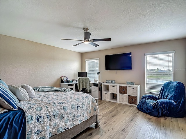 6812 Gideon Cir, Zephyrhills, FL 33541 - bedroom with light wood-type flooring, a textured ceiling, multiple windows, and a ceiling fan