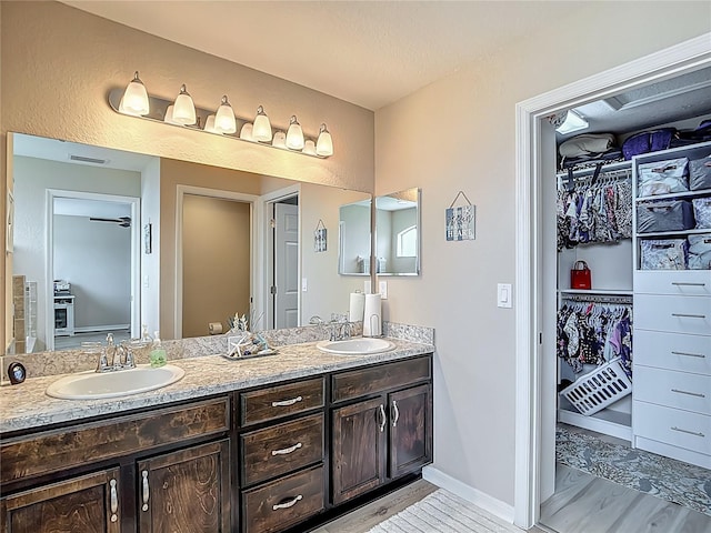 6812 Gideon Cir, Zephyrhills, FL 33541 - bathroom featuring double vanity, a spacious closet, and baseboards