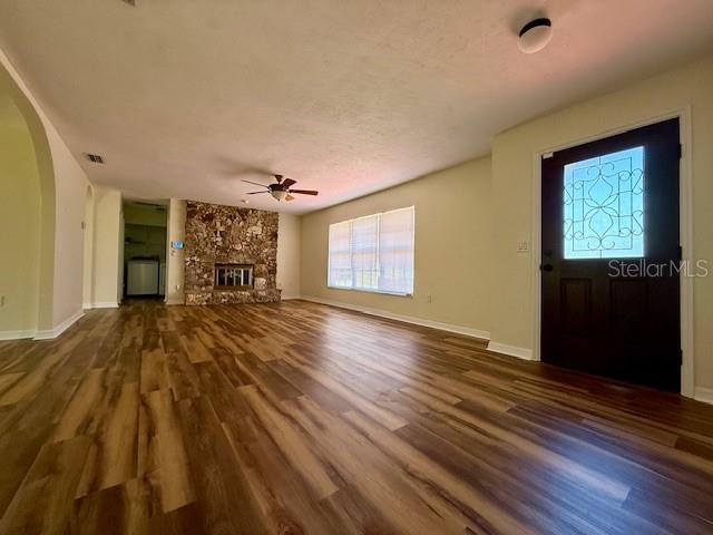 8770 SW 196th Terrace Rd, Dunnellon, FL 34432 - unfurnished living room featuring wood finished floors, plenty of natural light, a ceiling fan, and arched walkways