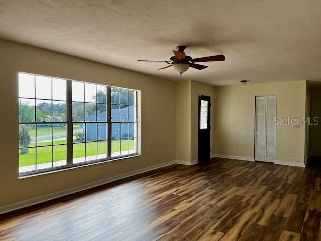 8770 SW 196th Terrace Rd, Dunnellon, FL 34432 - unfurnished room with baseboards, dark wood finished floors, and a ceiling fan