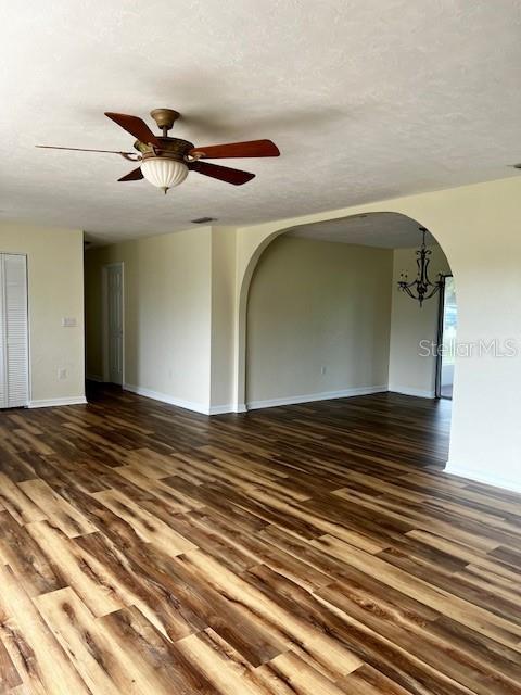 8770 SW 196th Terrace Rd, Dunnellon, FL 34432 - spare room featuring arched walkways, wood finished floors, baseboards, a ceiling fan, and a textured ceiling