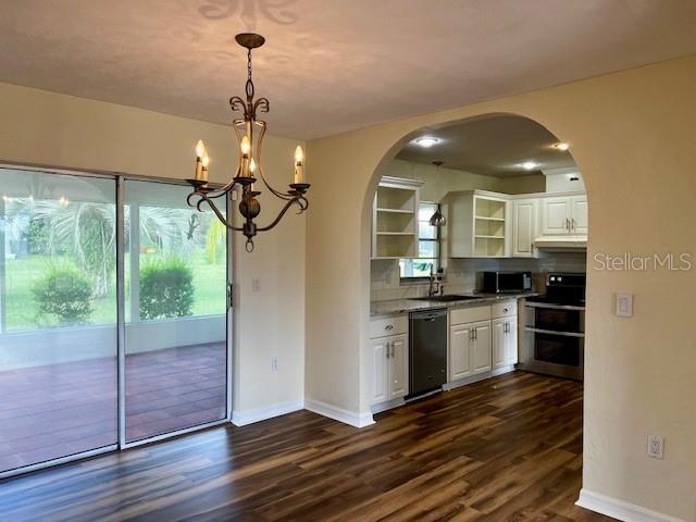 8770 SW 196th Terrace Rd, Dunnellon, FL 34432 - kitchen with appliances with stainless steel finishes, open shelves, arched walkways, and healthy amount of natural light