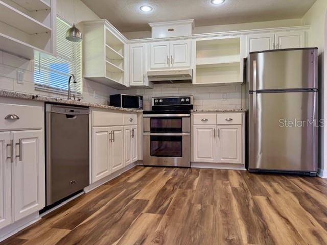 8770 SW 196th Terrace Rd, Dunnellon, FL 34432 - kitchen with open shelves, appliances with stainless steel finishes, under cabinet range hood, white cabinets, and recessed lighting