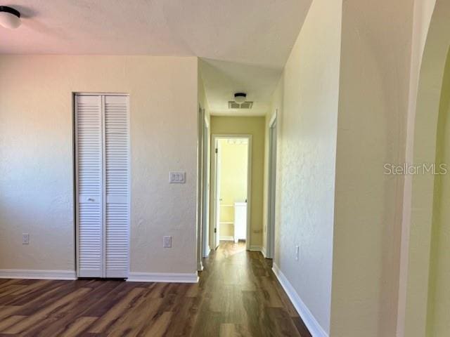 8770 SW 196th Terrace Rd, Dunnellon, FL 34432 - unfurnished bedroom featuring dark wood-style flooring, baseboards, a closet, and arched walkways