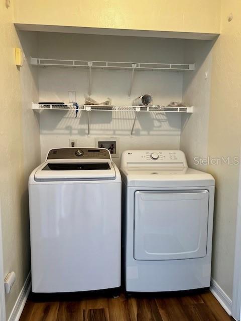 8770 SW 196th Terrace Rd, Dunnellon, FL 34432 - laundry area with washer and dryer, dark wood-type flooring, and baseboards