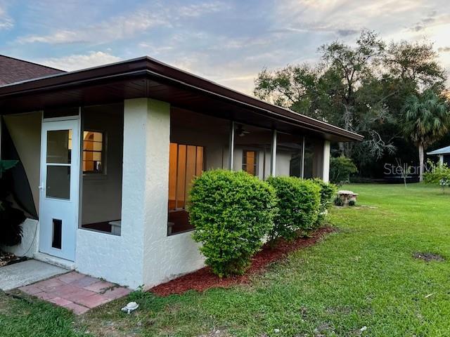 8770 SW 196th Terrace Rd, Dunnellon, FL 34432 - view of side of property with a lawn and stucco siding