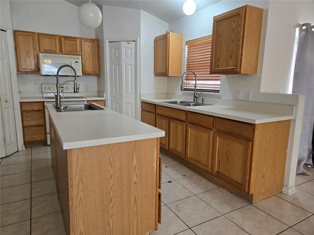 4460 SW 44th St, Ocala, FL 34474 - kitchen featuring white microwave, a sink, an island with sink, light countertops, and light tile patterned flooring