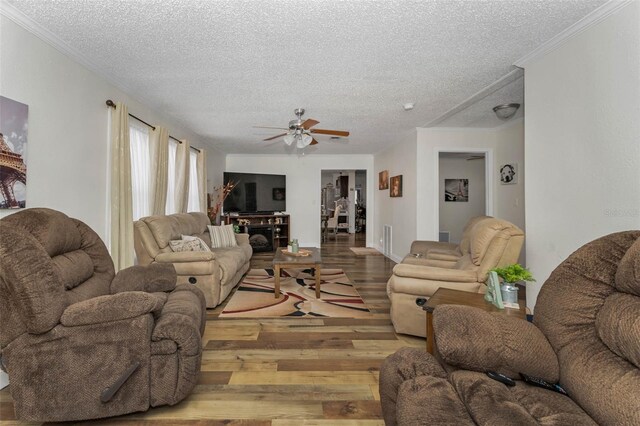 14276 SE 61st Ave, Summerfield, FL 34491 - living area featuring a textured ceiling, wood finished floors, a ceiling fan, and crown molding
