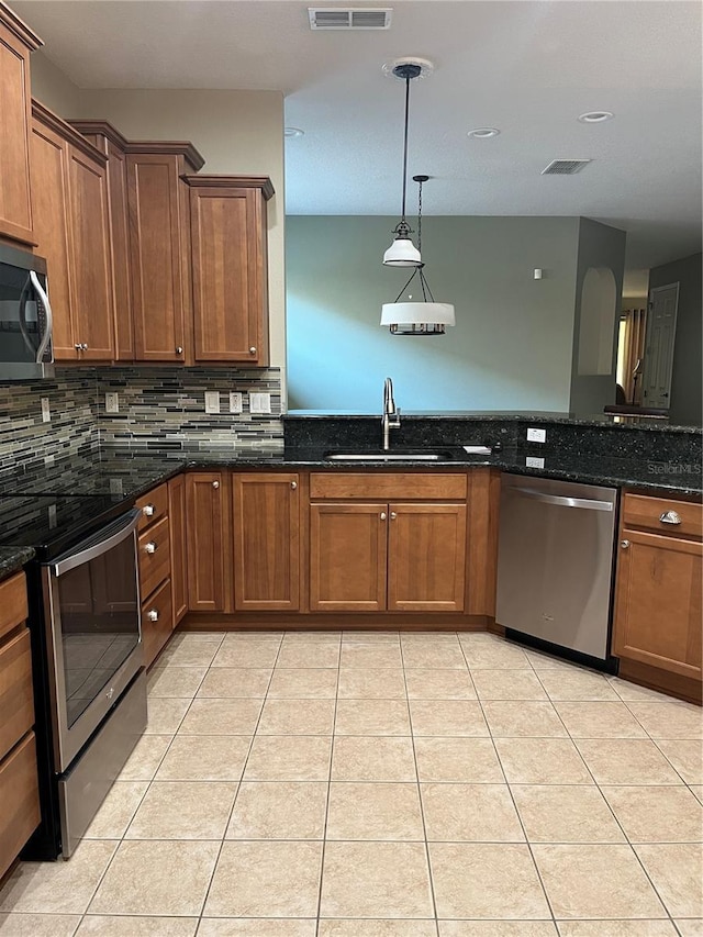 8447 SW 82nd Loop, Ocala, FL 34481 - kitchen with appliances with stainless steel finishes, a sink, decorative backsplash, dark stone counters, and light tile patterned flooring