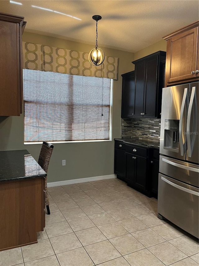 8447 SW 82nd Loop, Ocala, FL 34481 - kitchen with stainless steel refrigerator with ice dispenser, light tile patterned flooring, backsplash, dark stone countertops, and baseboards