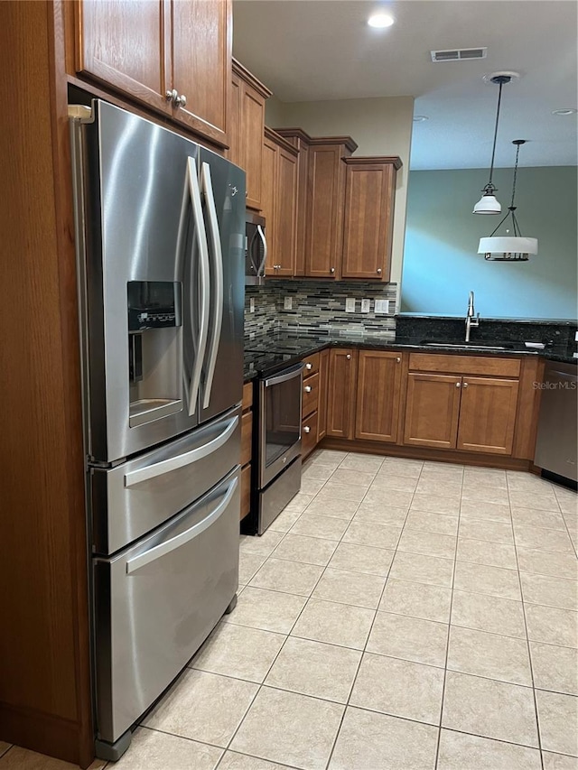 8447 SW 82nd Loop, Ocala, FL 34481 - kitchen with stainless steel appliances, a sink, decorative backsplash, light tile patterned flooring, and hanging light fixtures