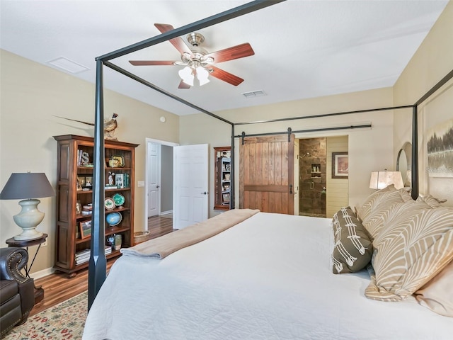 8447 SW 82nd Loop, Ocala, FL 34481 - bedroom with wood finished floors, baseboards, a barn door, and a ceiling fan