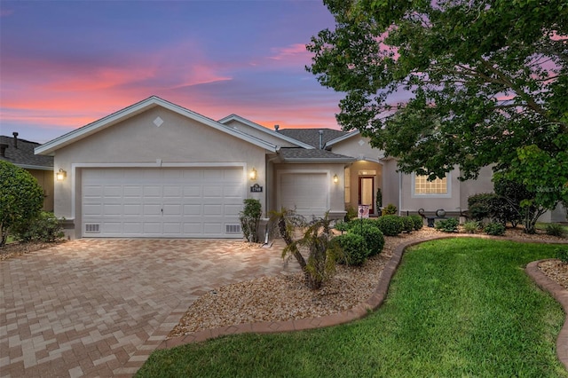 1748 SW 157th Place Rd, Ocala, FL 34473 - ranch-style house with stucco siding, a garage, decorative driveway, a lawn, and roof with shingles
