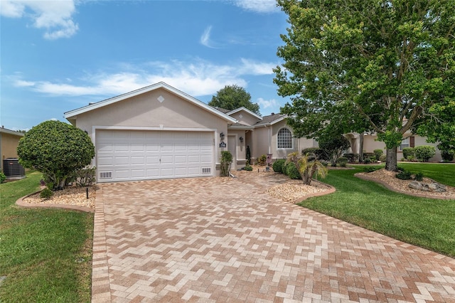 1748 SW 157th Place Rd, Ocala, FL 34473 - single story home featuring decorative driveway, stucco siding, an attached garage, a front lawn, and central AC unit