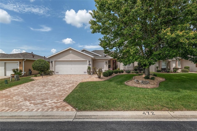 1748 SW 157th Place Rd, Ocala, FL 34473 - ranch-style house featuring stucco siding, a garage, decorative driveway, and a front yard