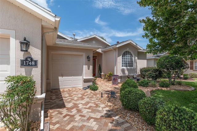 1748 SW 157th Place Rd, Ocala, FL 34473 - view of front facade with stucco siding, an attached garage, and decorative driveway