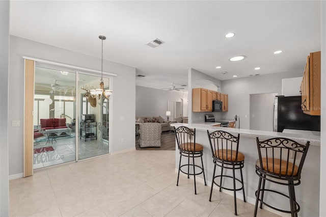 1748 SW 157th Place Rd, Ocala, FL 34473 - kitchen featuring ceiling fan, stainless steel appliances, light countertops, a breakfast bar, and baseboards