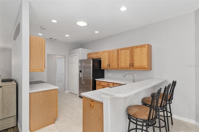 1748 SW 157th Place Rd, Ocala, FL 34473 - kitchen with stainless steel refrigerator with ice dispenser, a breakfast bar area, a peninsula, light countertops, and recessed lighting