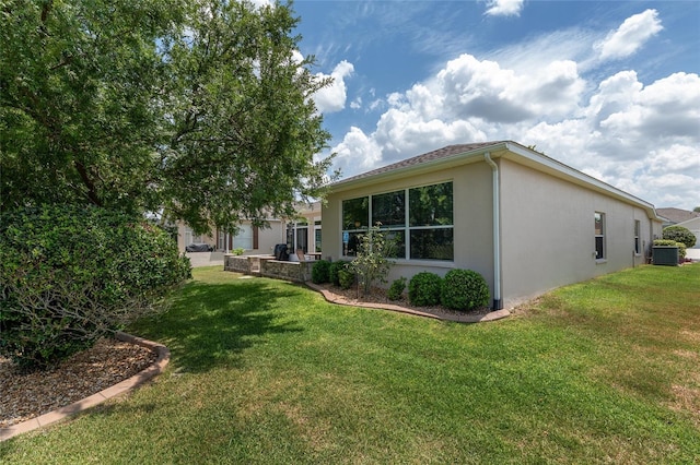 1748 SW 157th Place Rd, Ocala, FL 34473 - back of house featuring stucco siding, a lawn, and central AC unit