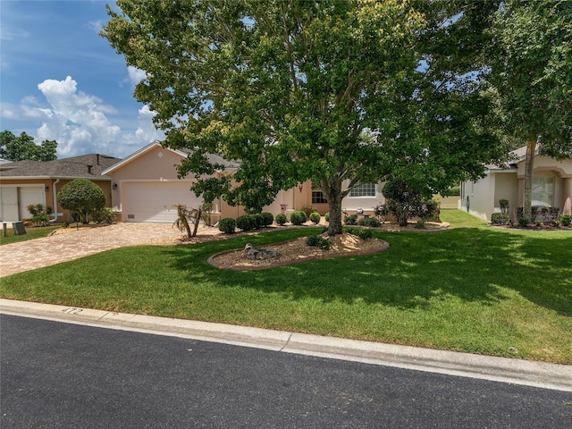 1748 SW 157th Place Rd, Ocala, FL 34473 - view of front facade with decorative driveway, stucco siding, an attached garage, and a front lawn